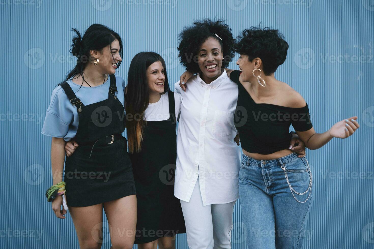 Laughing women in front of a blue wall photo