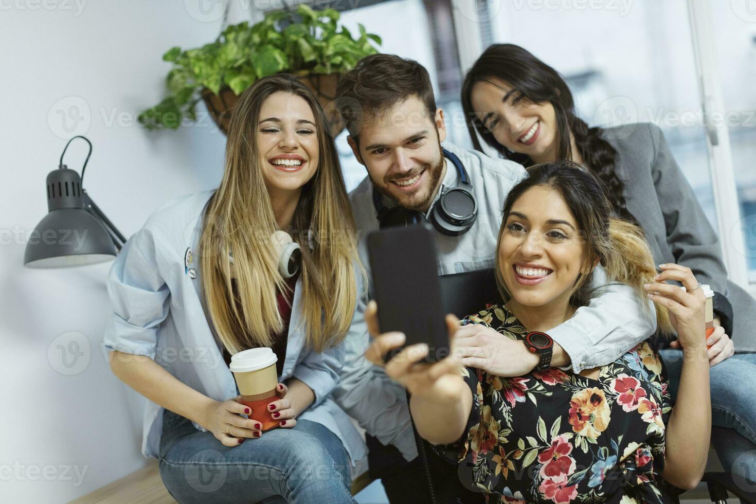 contento casual compañeros de trabajo en el oficina tomando un selfie foto