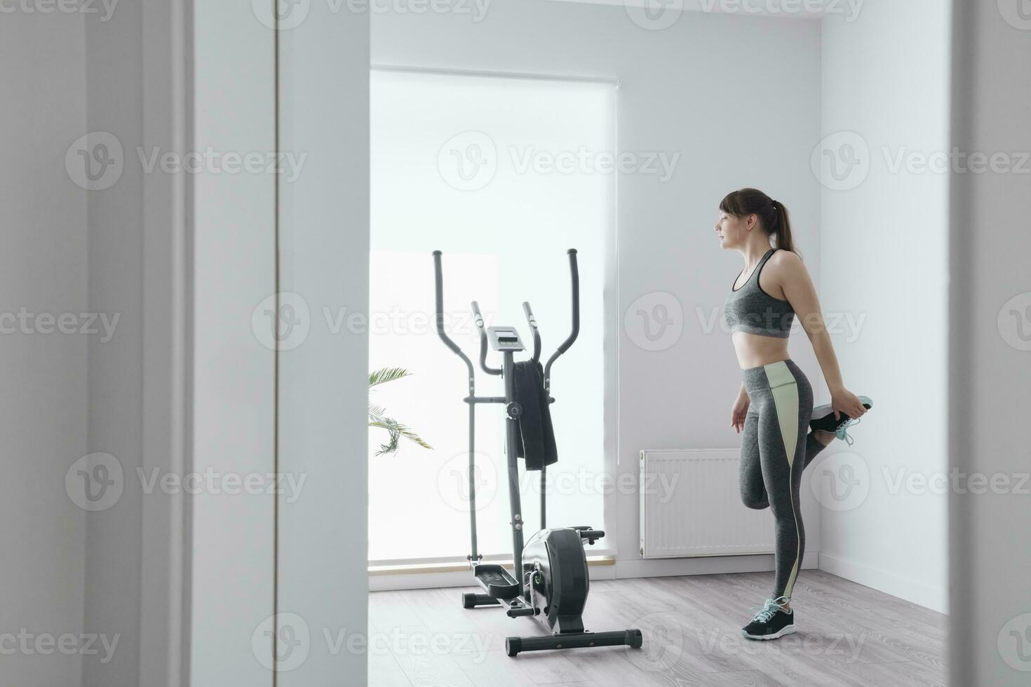 Woman performing stretching exercises before a workout at home photo