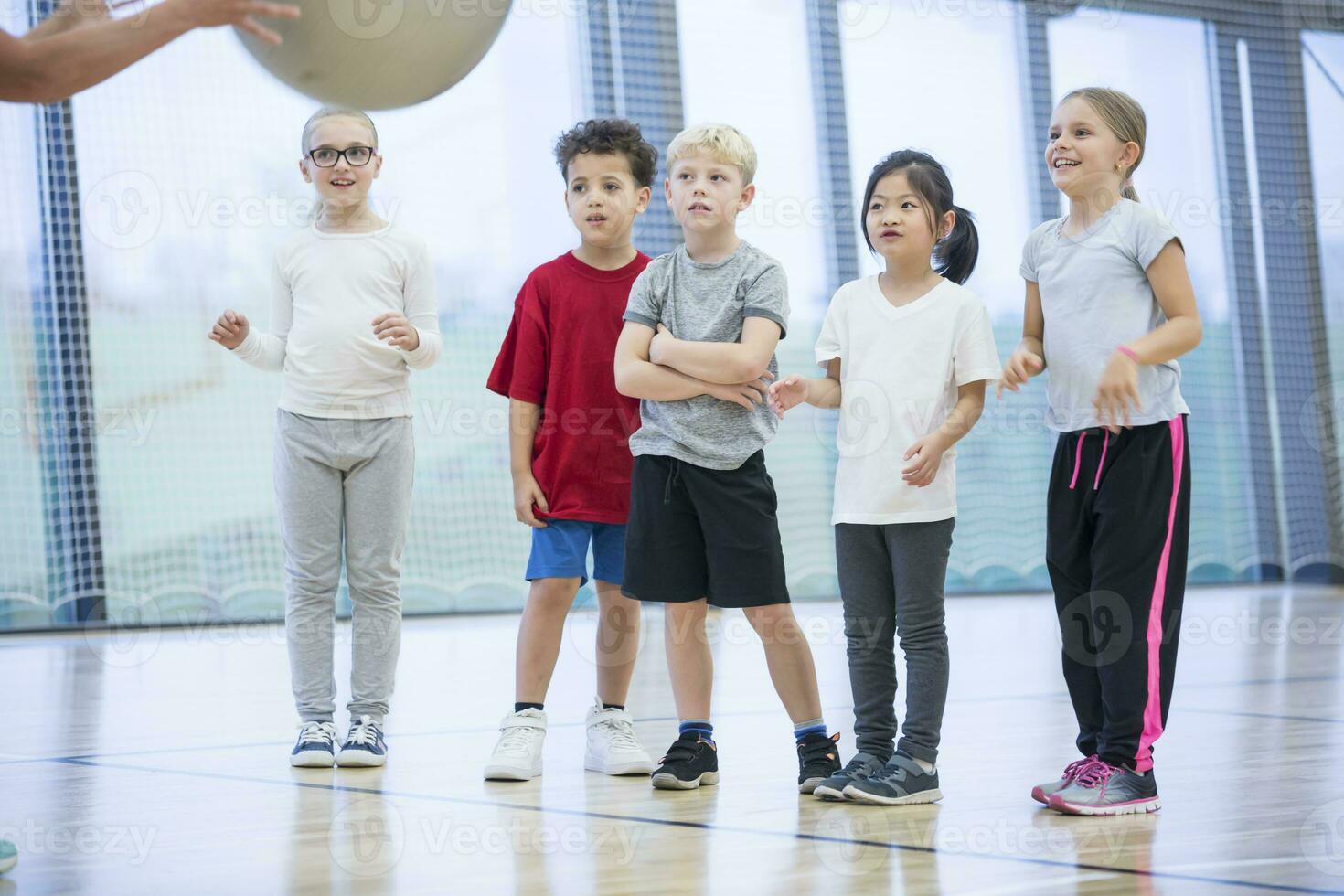 Pupils in gym class looking at teacher photo