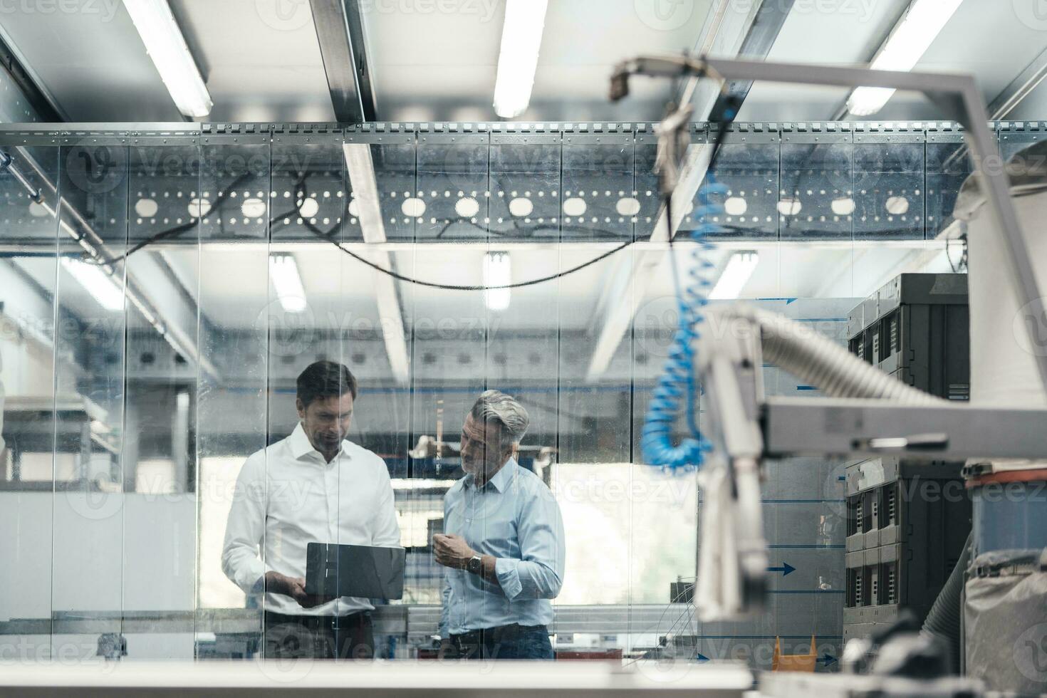 Expertise working on laptop while standing in workshop at industry photo