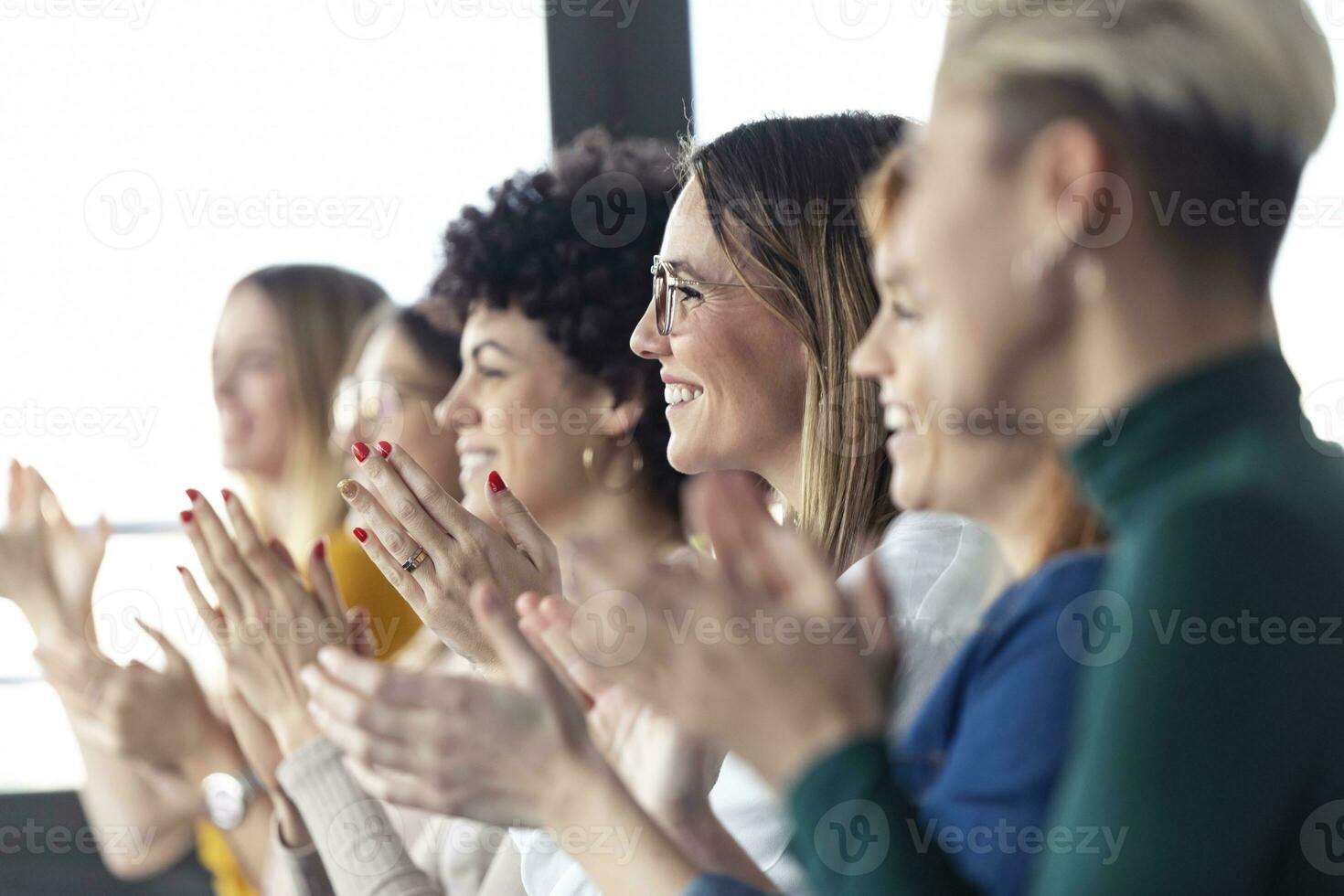 Businesswomen clapping hands during a training photo