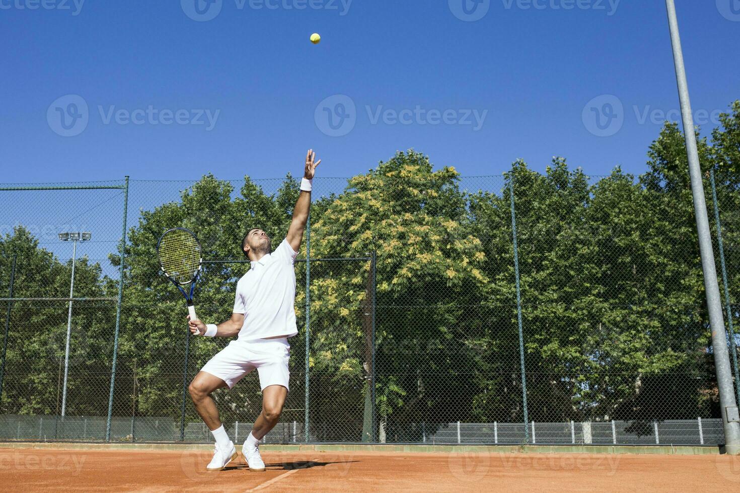 tenis jugador servicio un tenis pelota durante un tenis partido foto
