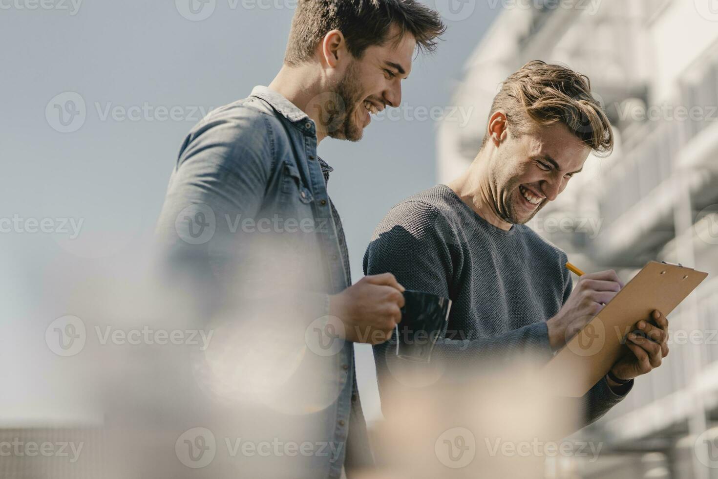 Colleagues brainstorming on balcony, writing down their ideas photo