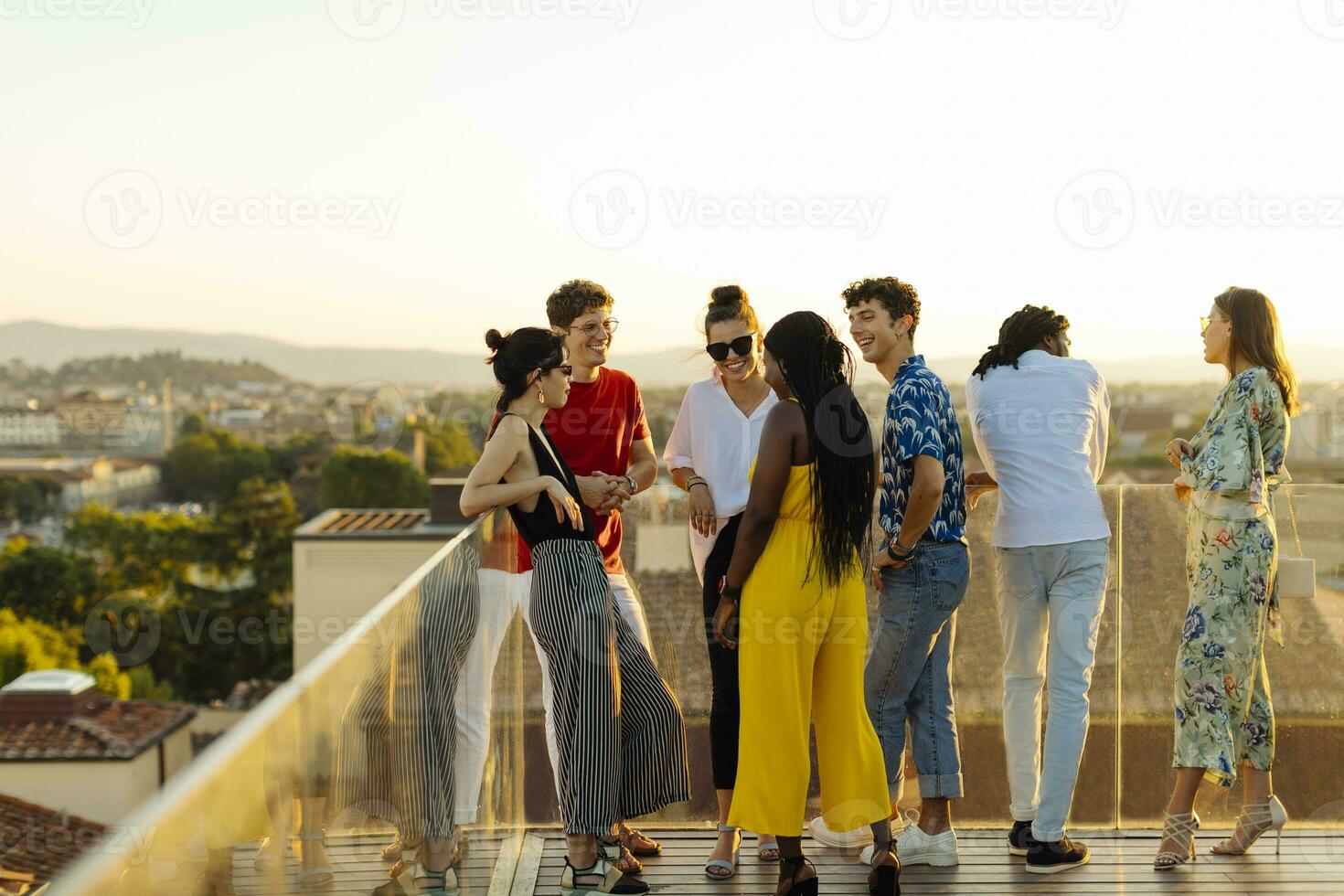 Group of happy multi-ethnic friends celebrating a party in the evening photo