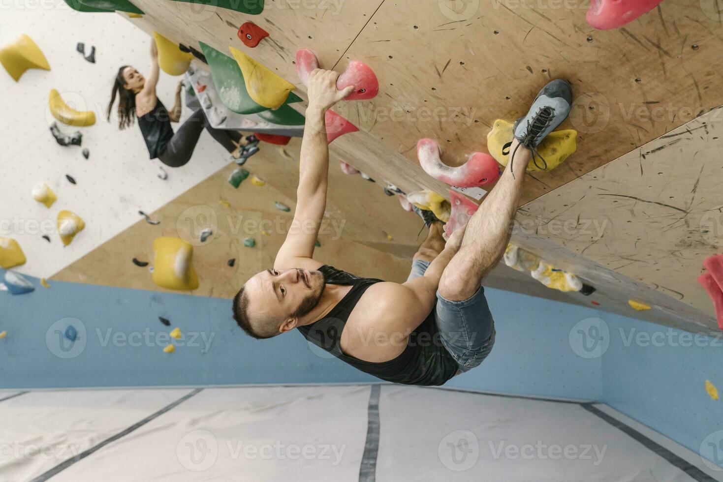 Man and woman bouldering in climbing gym photo