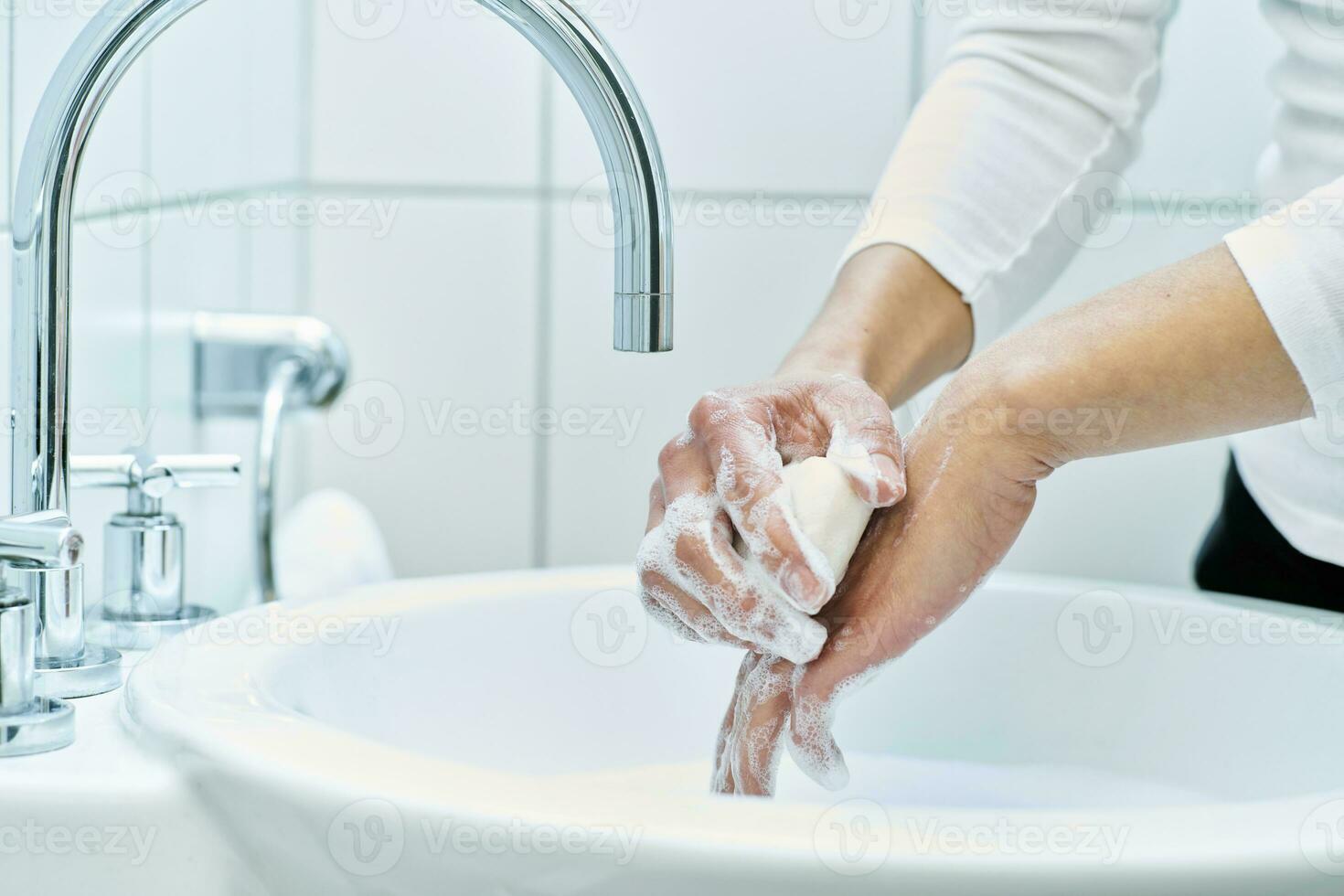 Woman washing her hand with soap photo