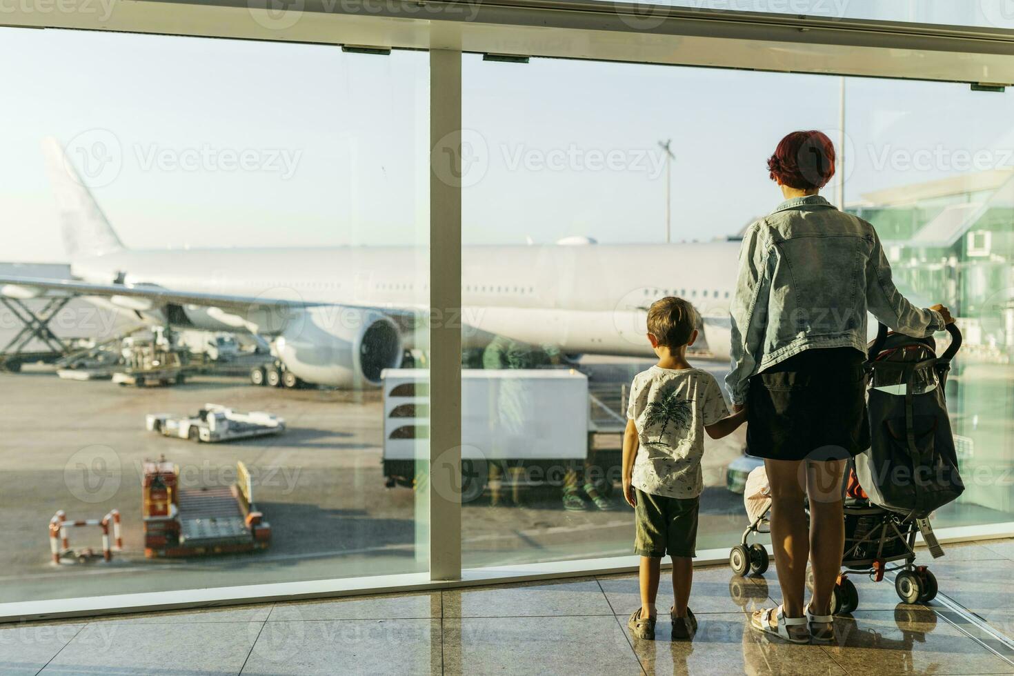 Spain, Barcelona airport, Mother and son waiting in departure area photo