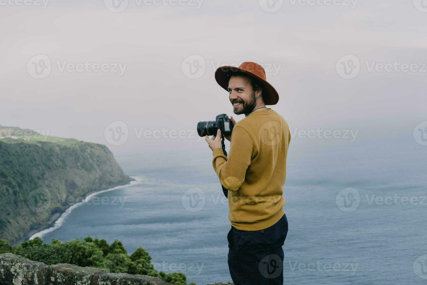 Smiling man with a camera at the coast on Sao Miguel Island, Azores, Portugal photo