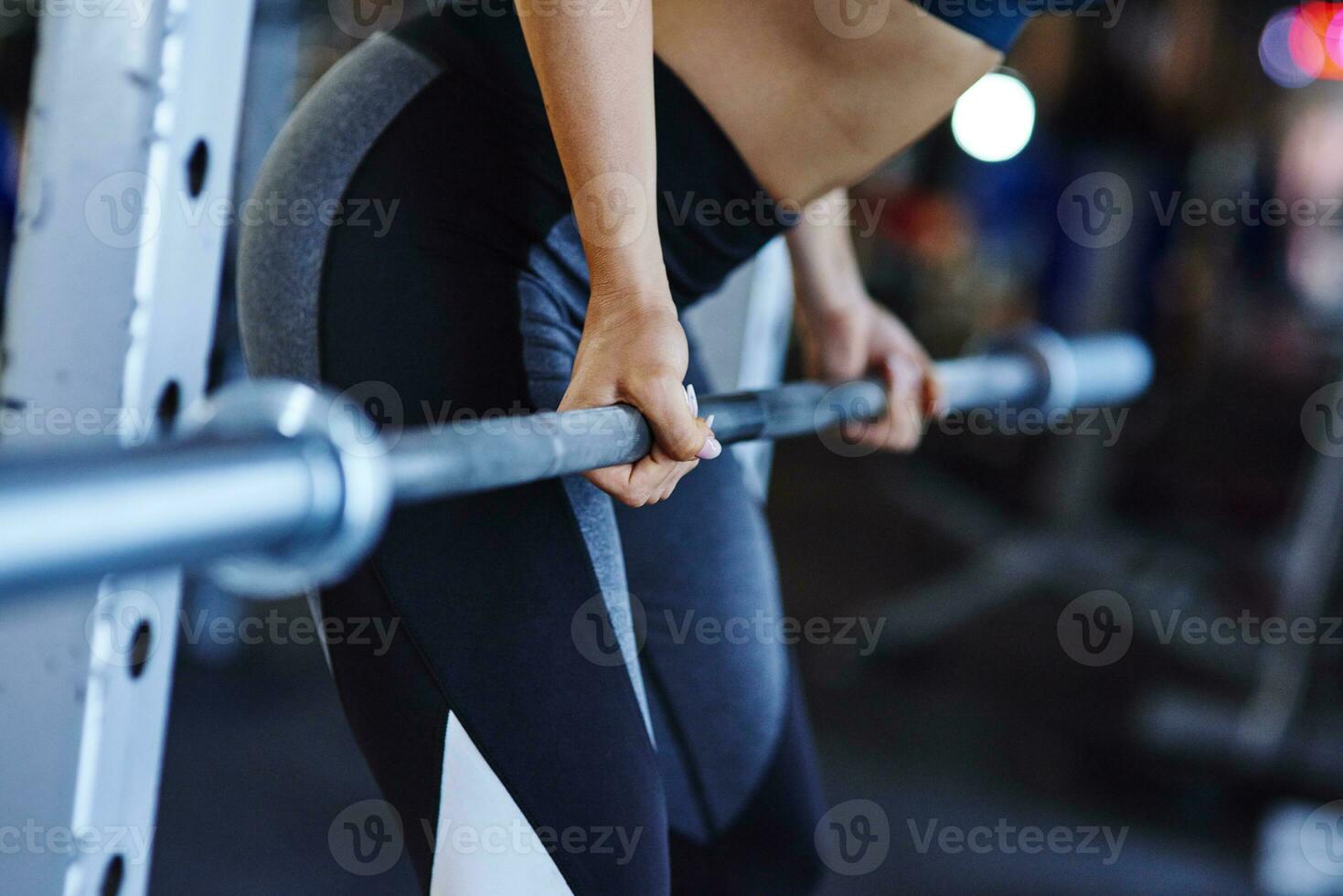 Woman lifting barbell in gym photo