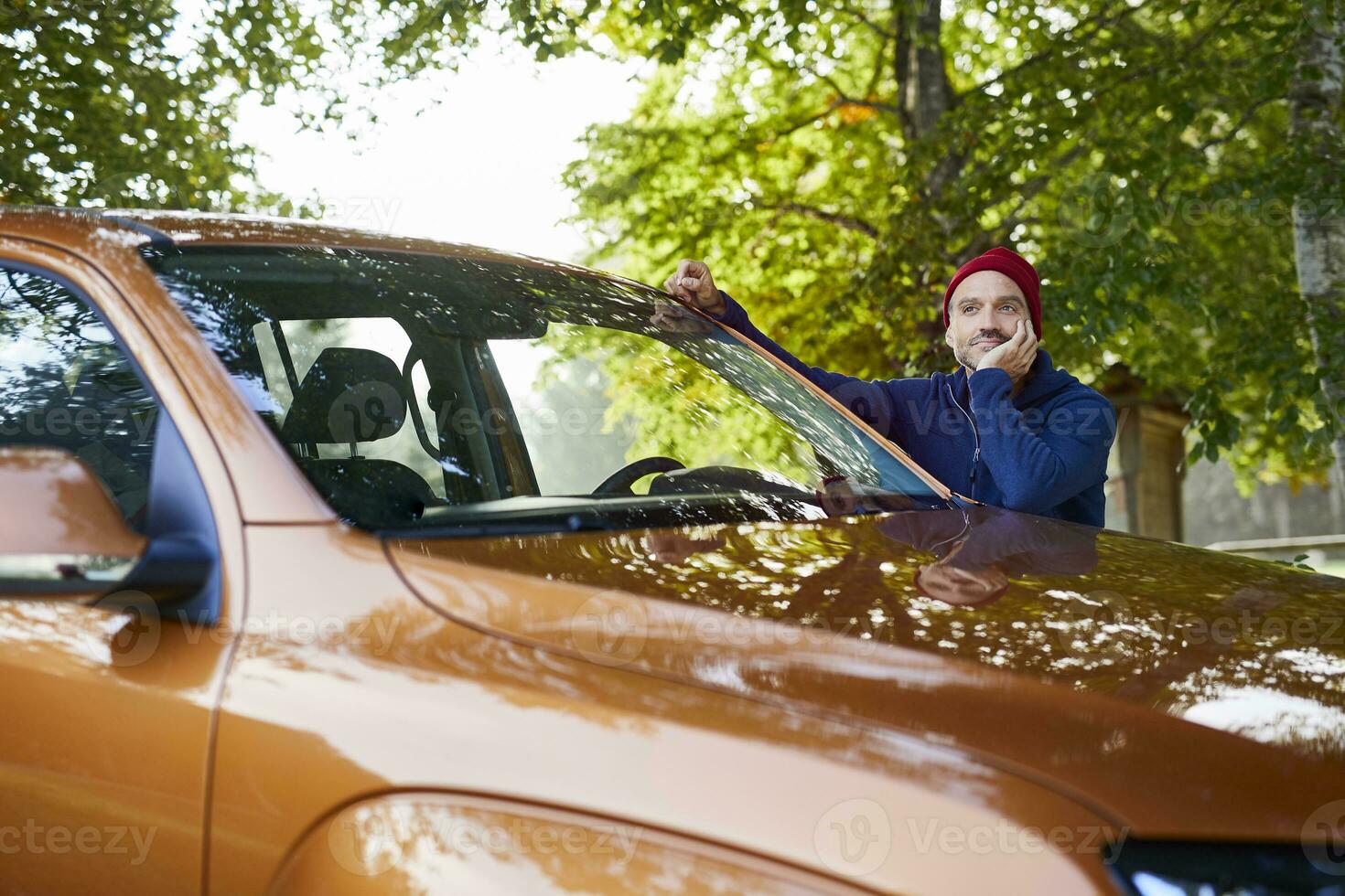 Mature man leaning on car in nature photo