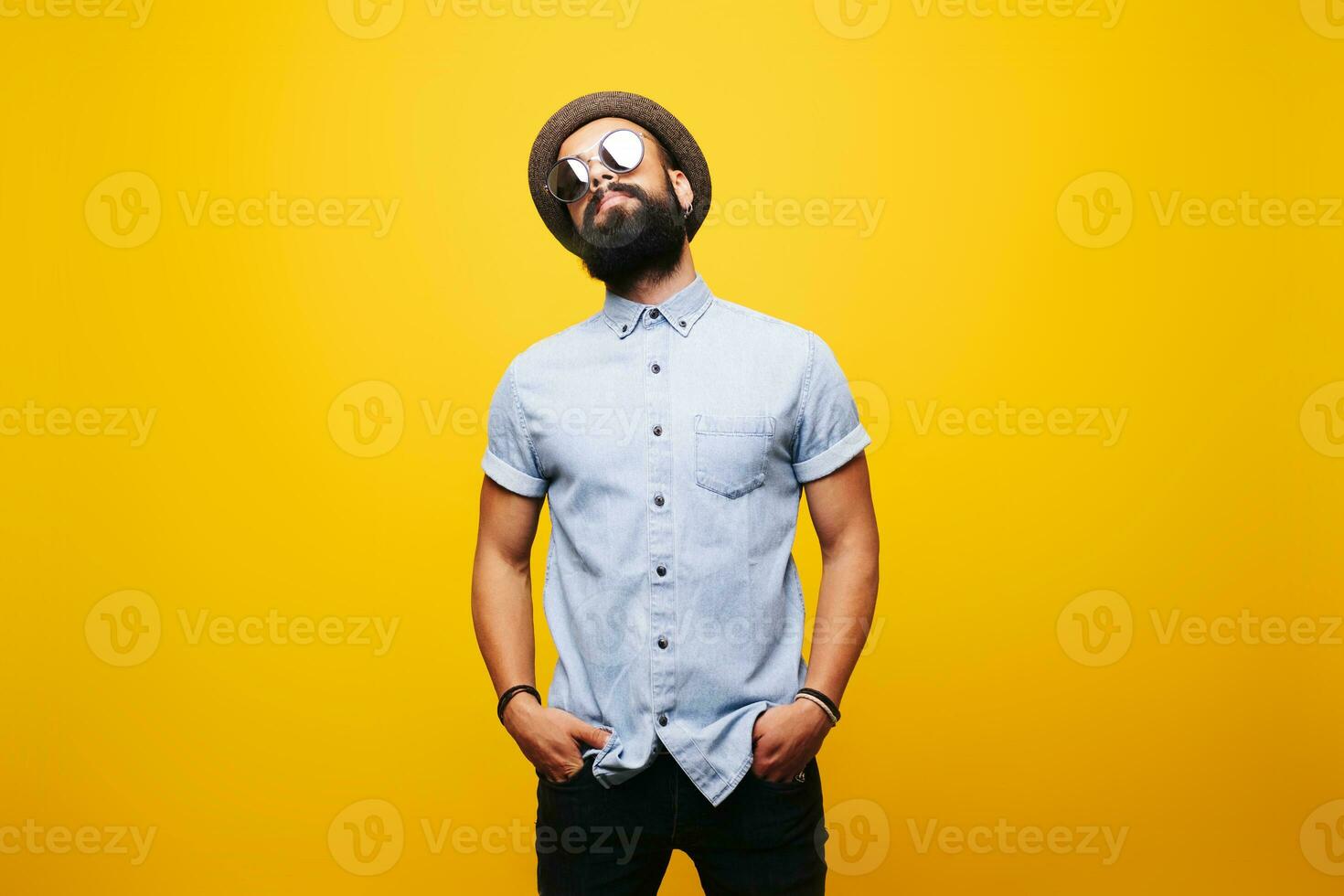 retrato de un elegante joven hombre en estudio vistiendo Gafas de sol foto