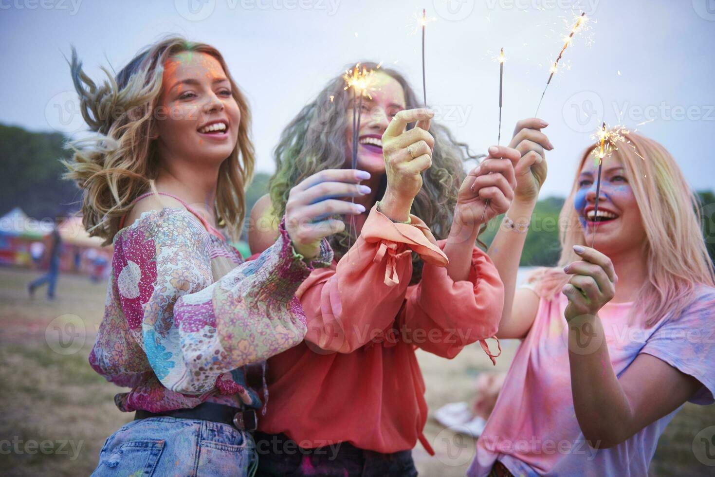 Portrait of friends with sparkler at music festival photo