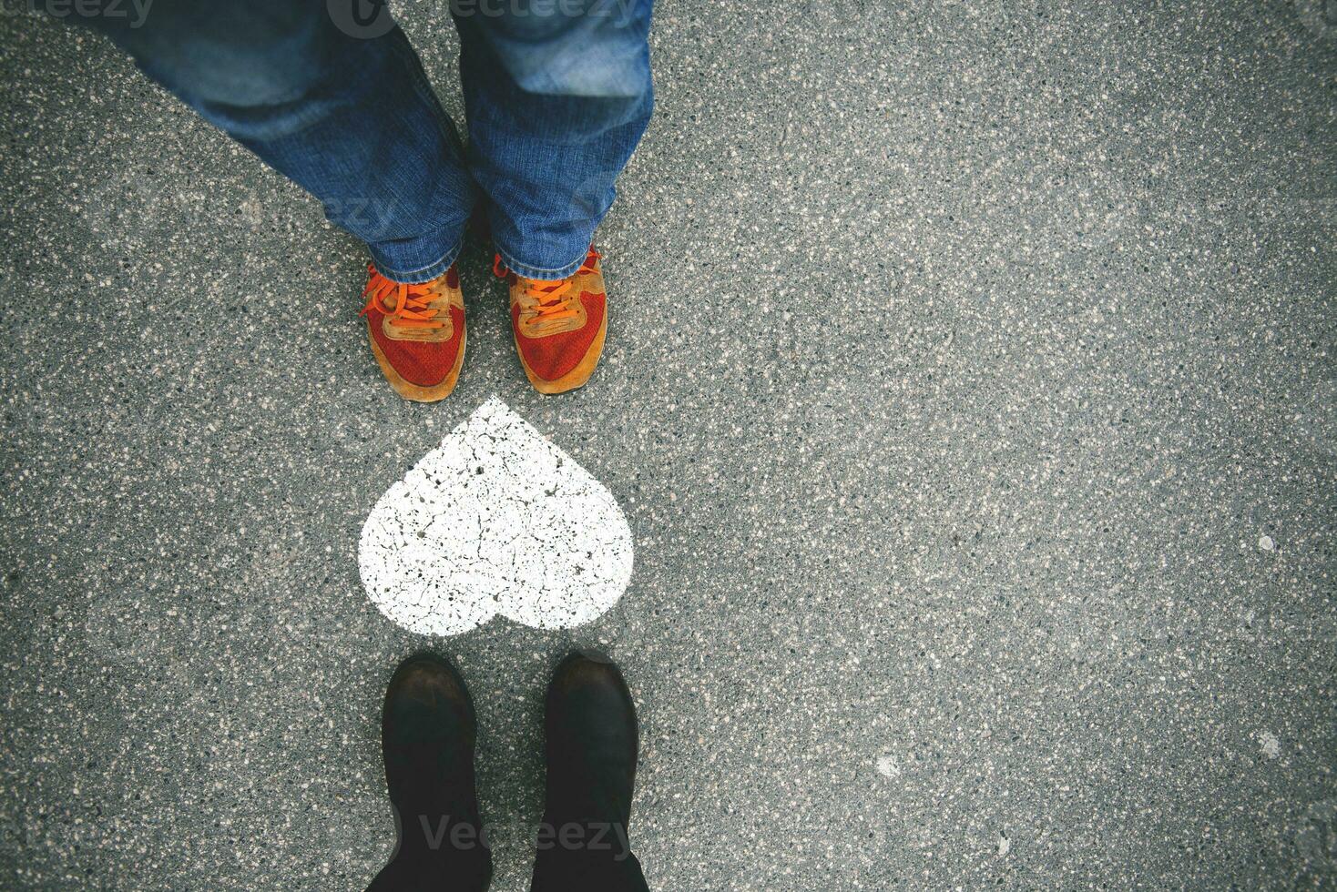 Hungary, Budapest, Feet of man and woman standing by heart on tarmac photo