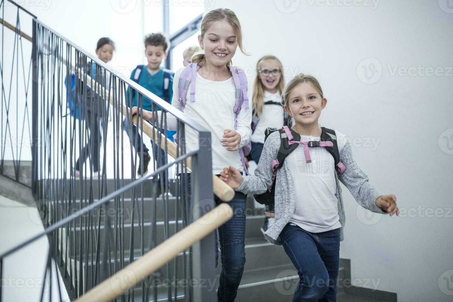 Happy pupils on staircase leaving school photo