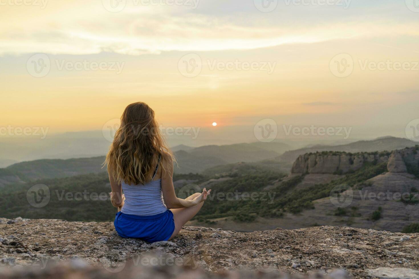 Spain, Catalonia, Sant Llorenc del Munt i l'Obac, Woman meditating in the mountains photo