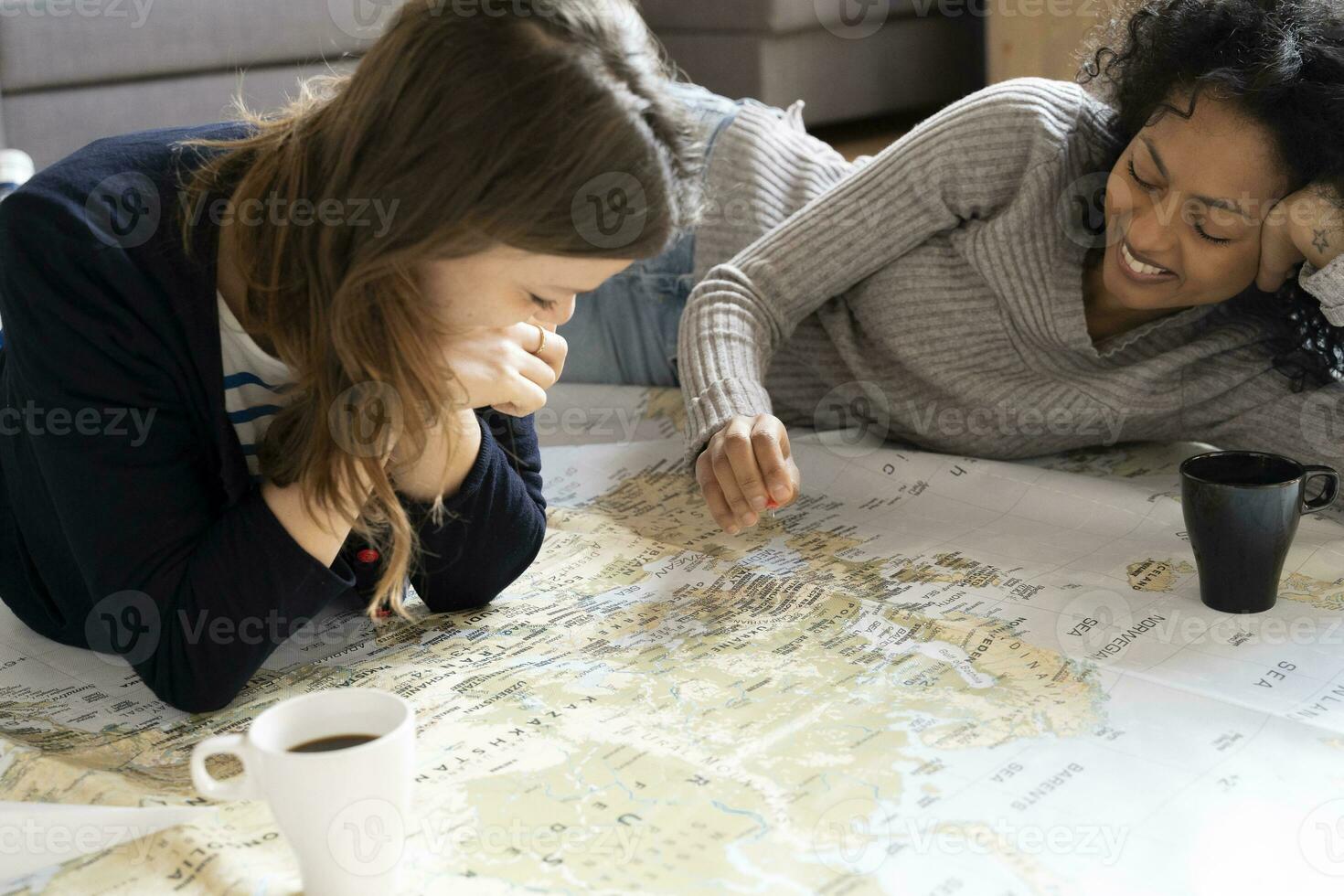 Friends putting pins on a map, planning their vacations photo