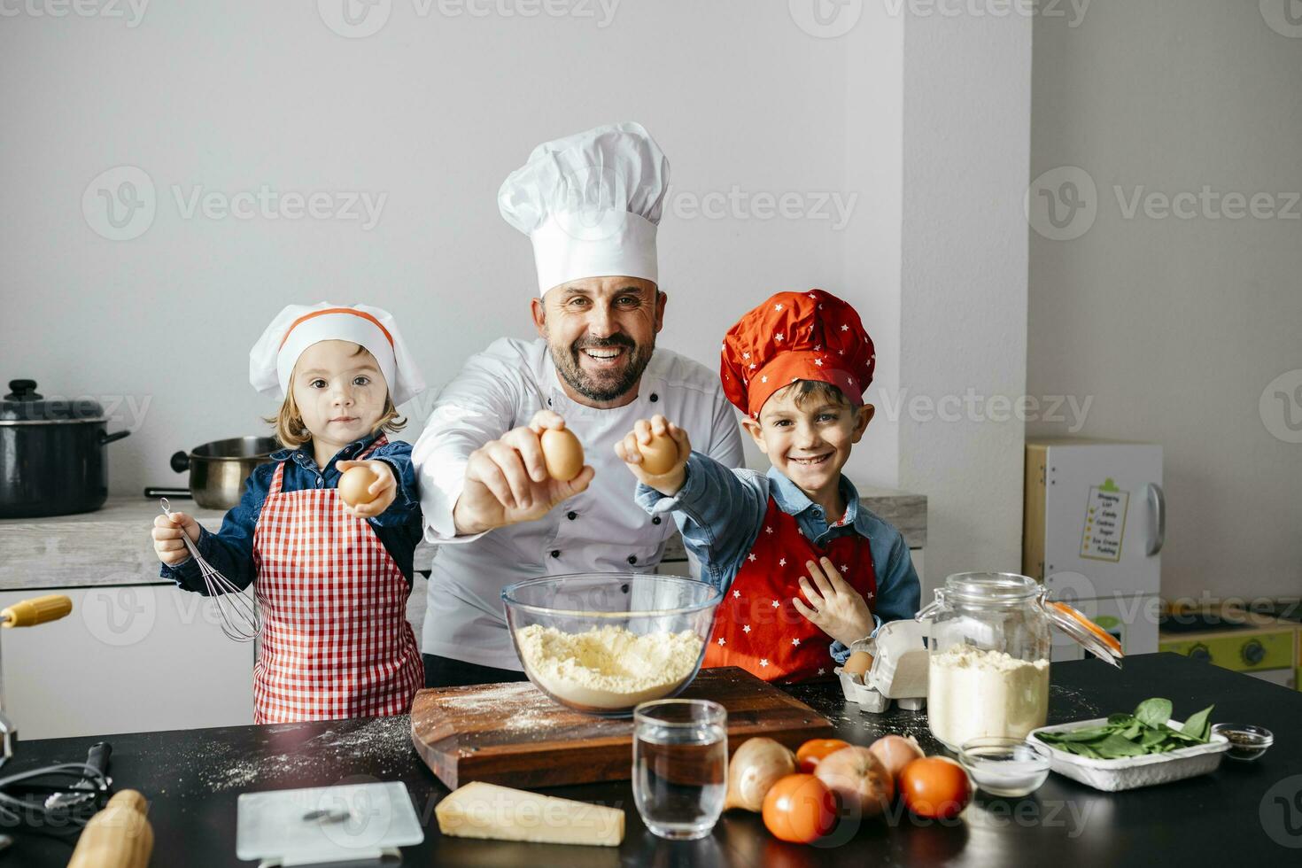 Portrait of father with two kids preparing dough in kitchen at home photo