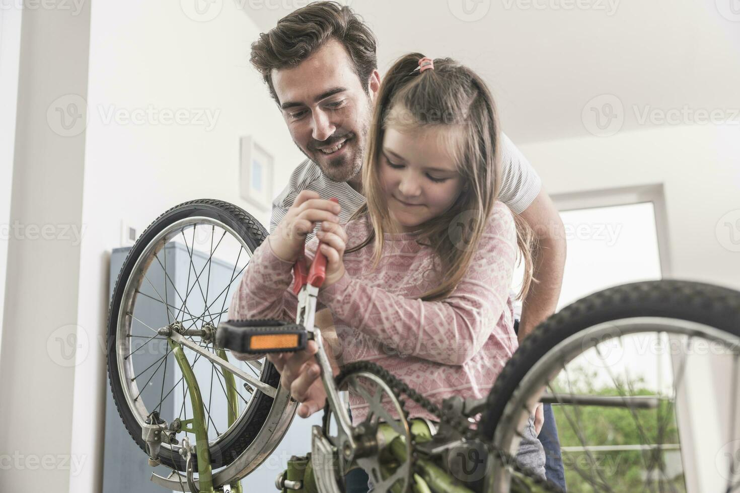 Young man and little girl repairing bicycle together photo