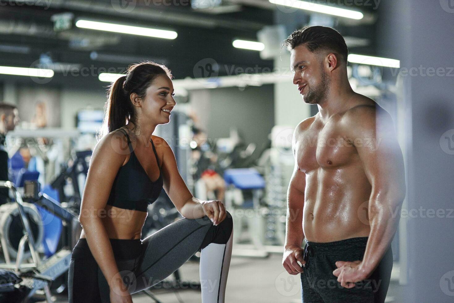 sonriente hombre y mujer hablando a el gimnasio foto