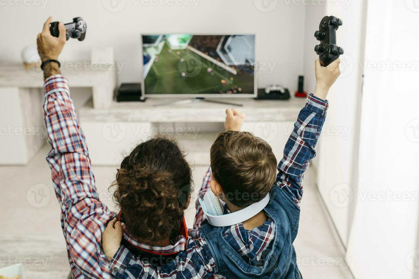 Father and son playing computer game at home photo