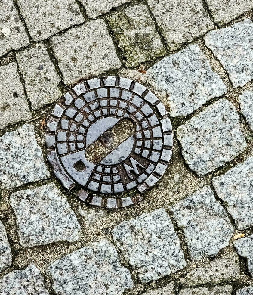 Closed sewer manhole on an old paved road.Top view photo