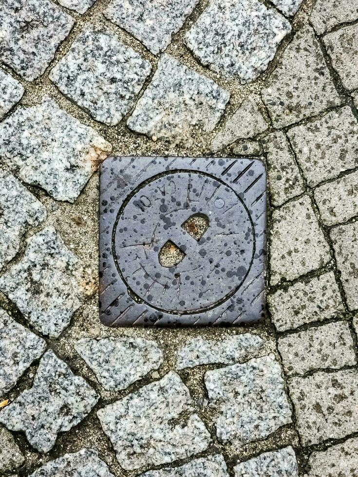 tapa de alcantarilla del sistema de gasoductos. una escotilla metálica masiva para el acceso a las comunicaciones de la ciudad en el pavimento. foto