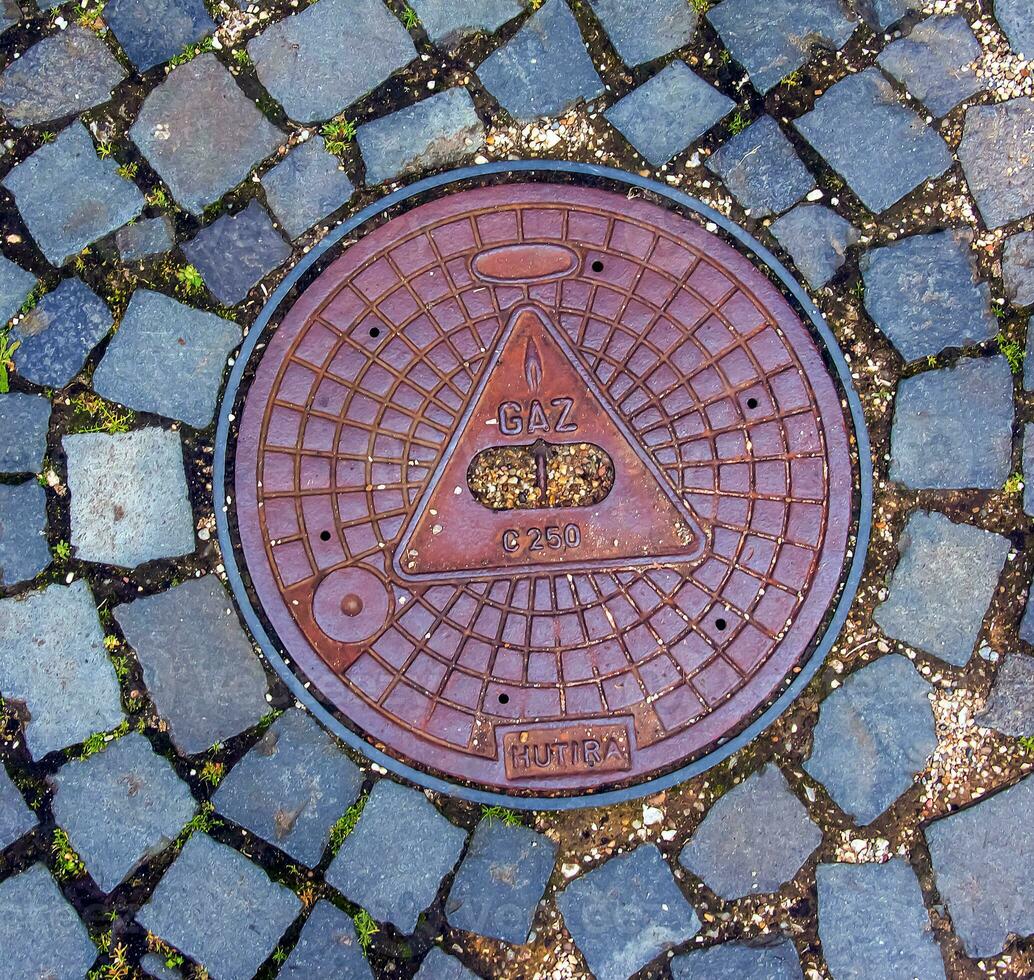 Manhole cover of the gas pipeline system. A massive metal hatch for access to city communications in the pavement. photo