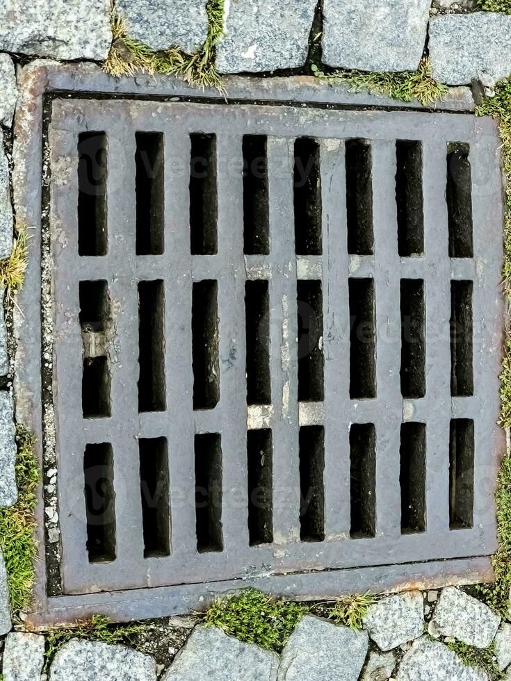 Open sewer manhole on an old paved road.Top view photo