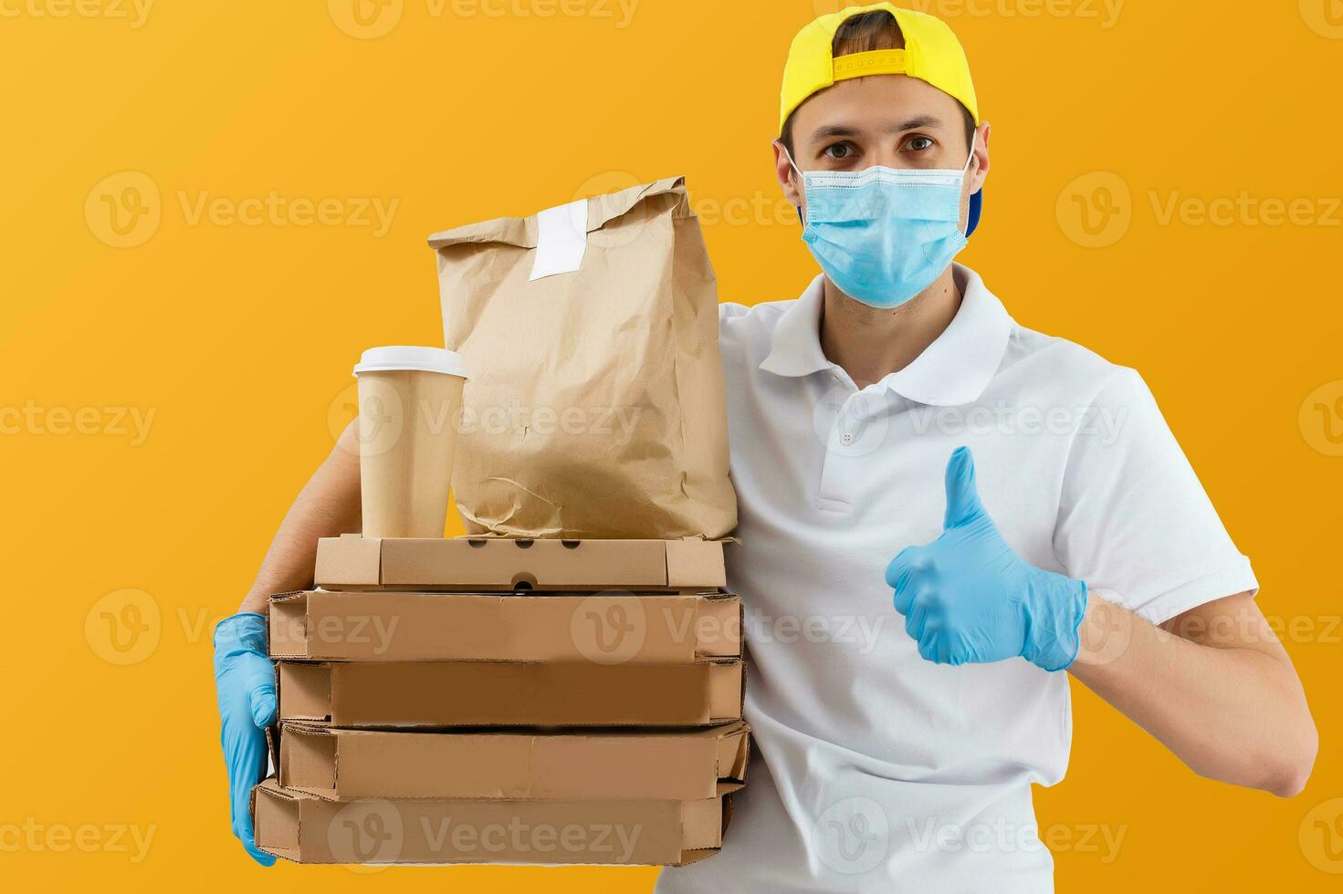 Delivery man in mask and gloves bring fresh food to customer's home. Stay home. Online shopping concept. yellow background photo