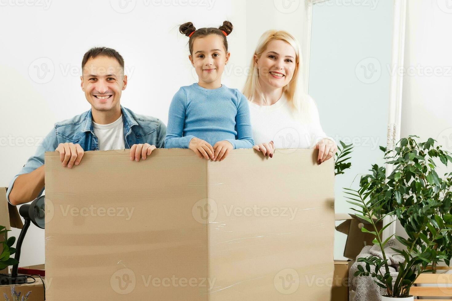 Happy family sitting on wooden floor. Father, mother and child having fun together. Moving house day, new home and design interior concept photo