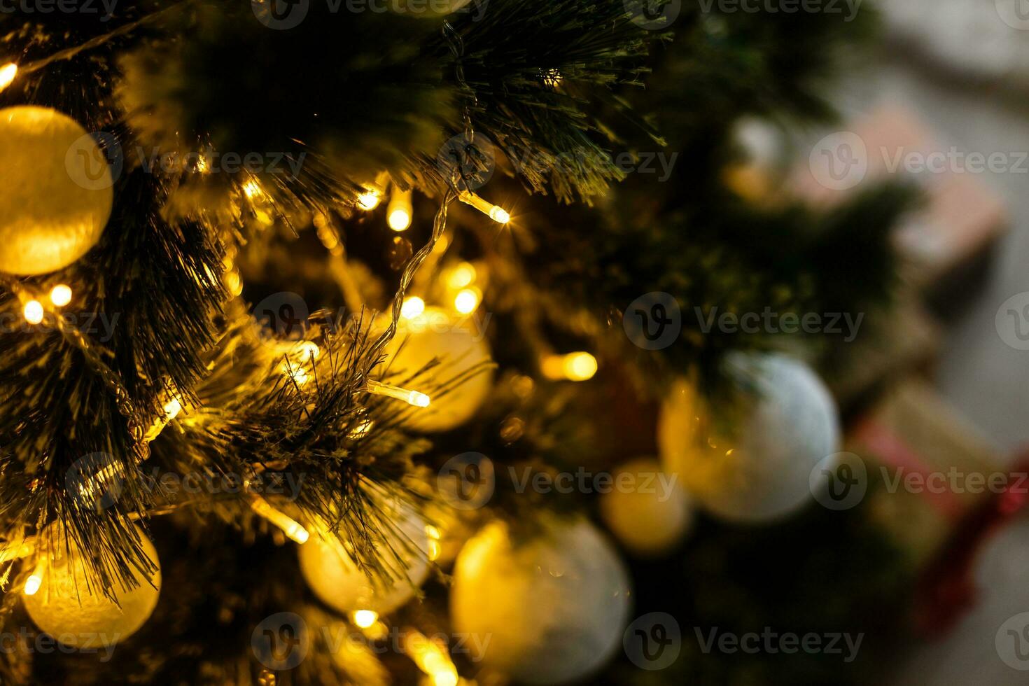 Fir branch with balls and festive lights on the Christmas background with sparkles. photo