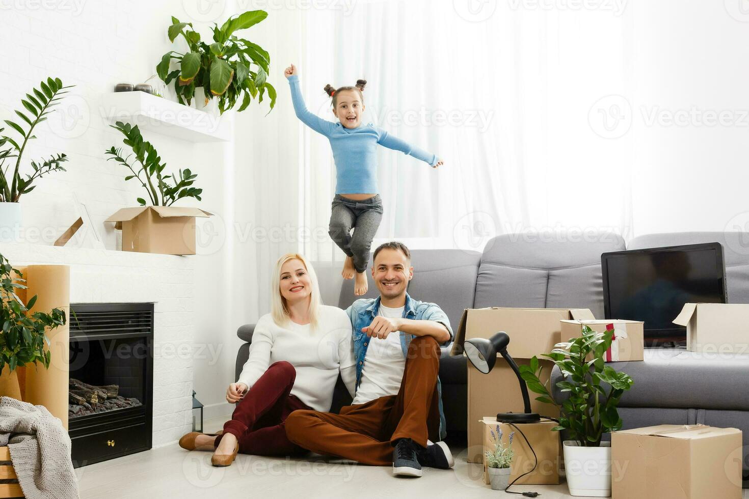 contento familia sentado en de madera piso. padre, madre y niño teniendo divertido juntos. Moviente casa día, nuevo hogar y diseño interior concepto foto