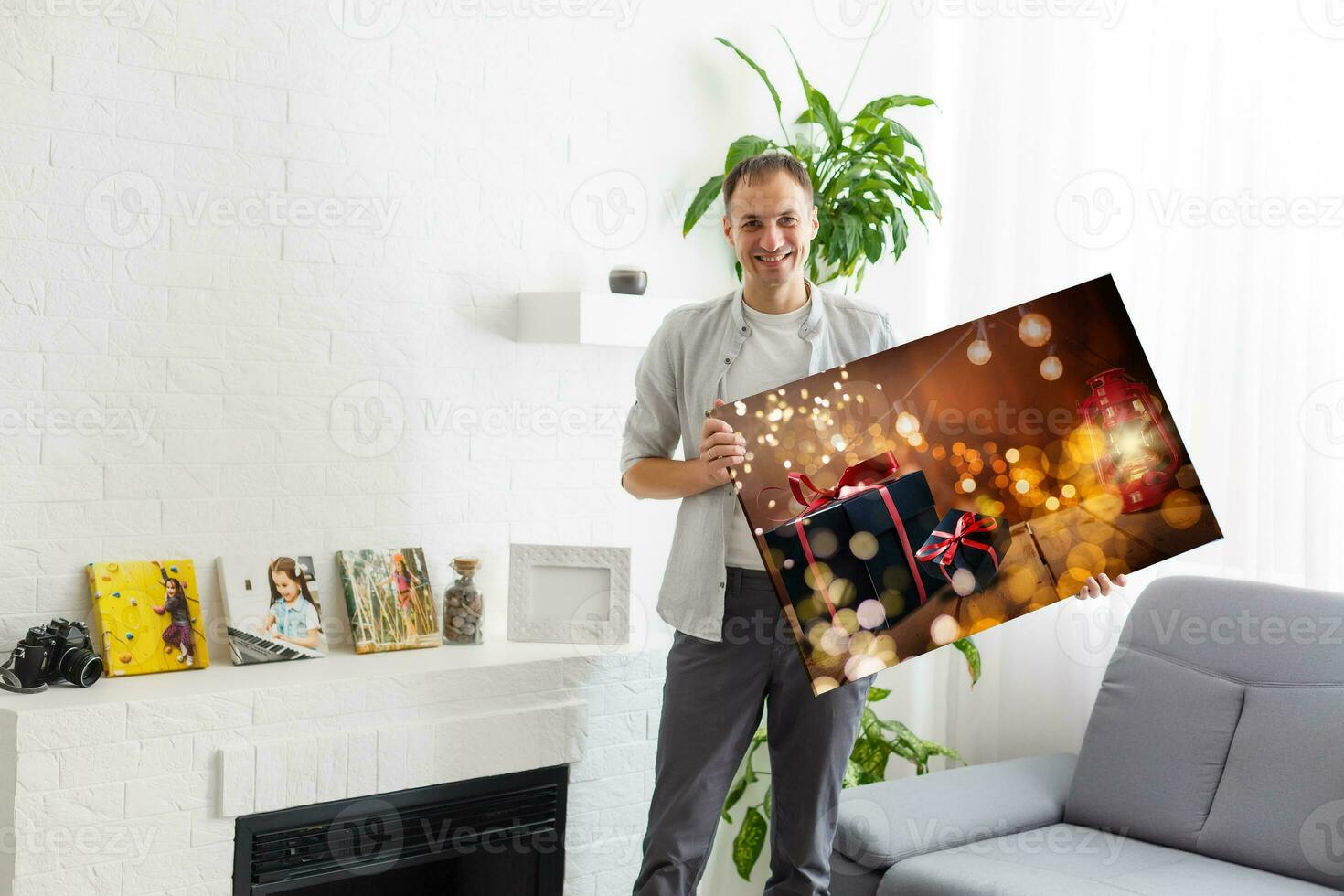 man holds photo canvas at home