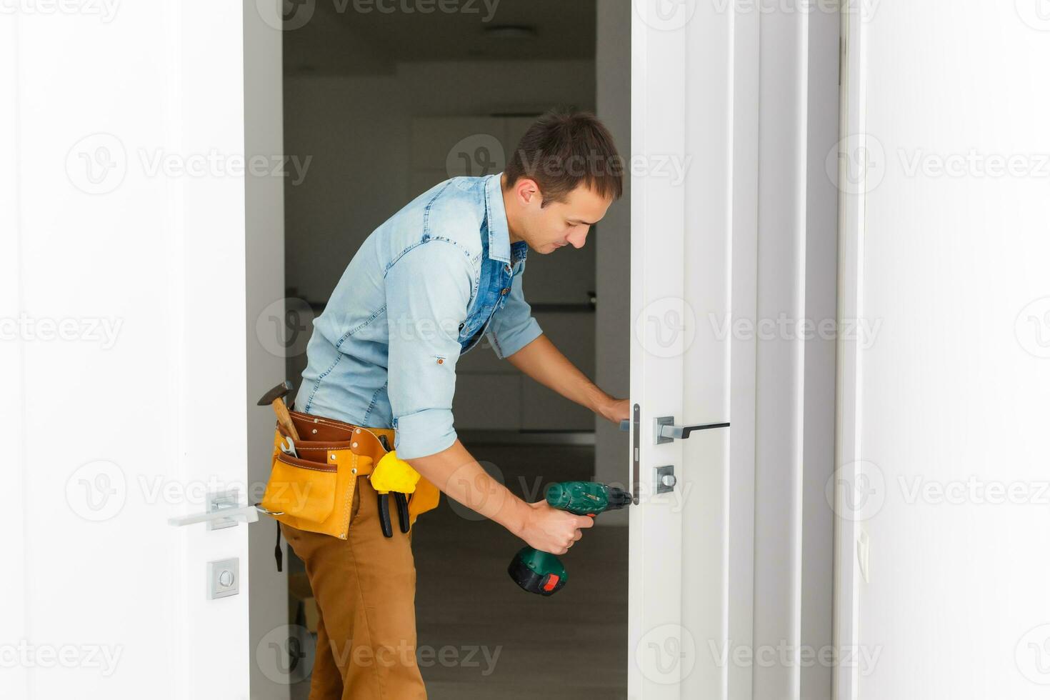 Master with screwdriver installs door hinges. photo