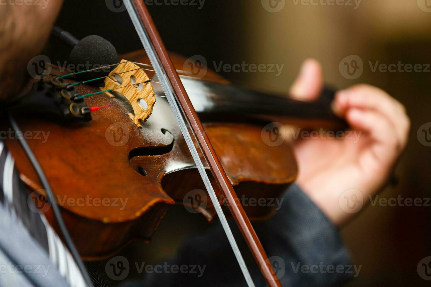 Playing violin, a man plays vintage violin on a concert, close up photo