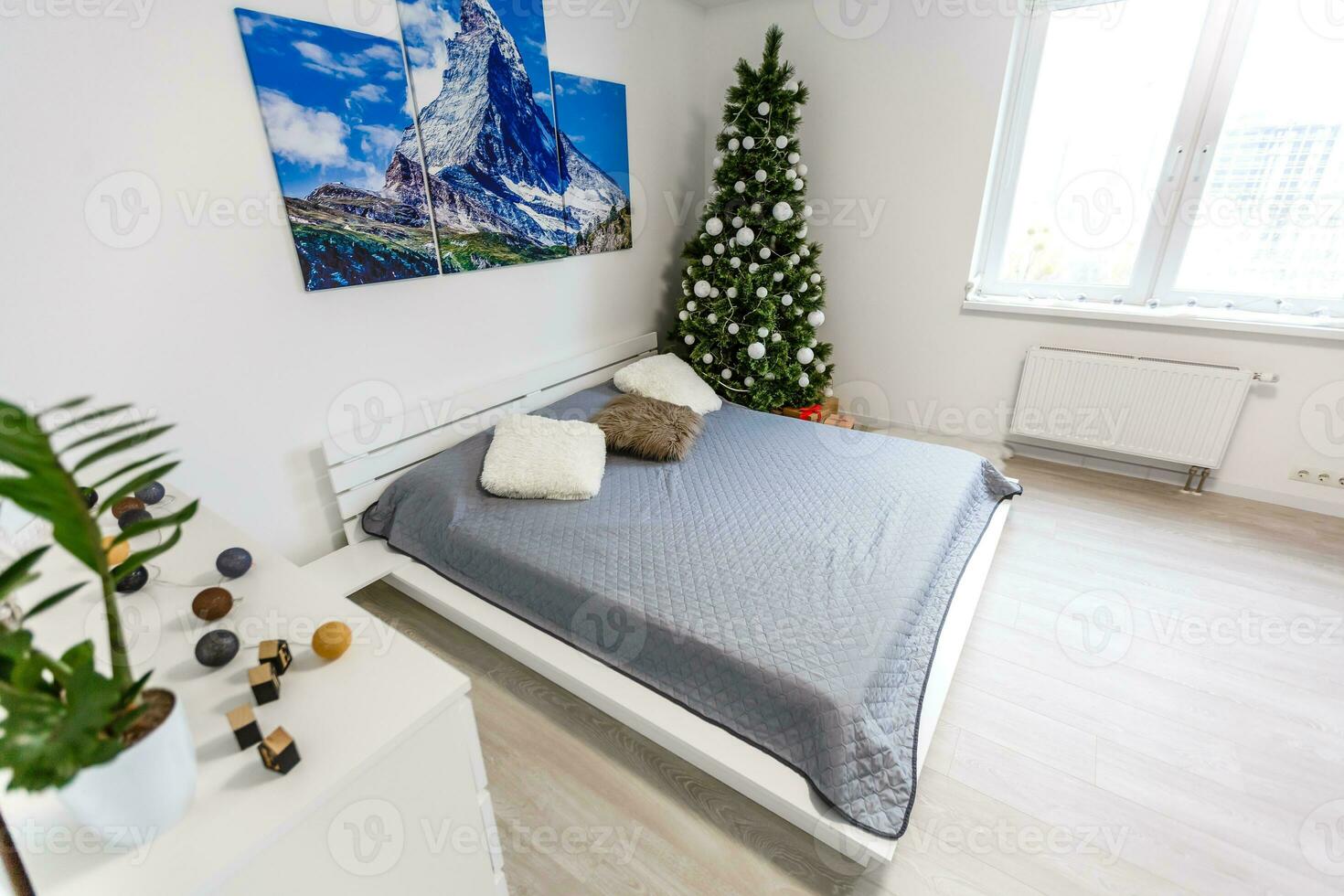 Calm image of interior Classic New Year Tree decorated in a room with bed photo