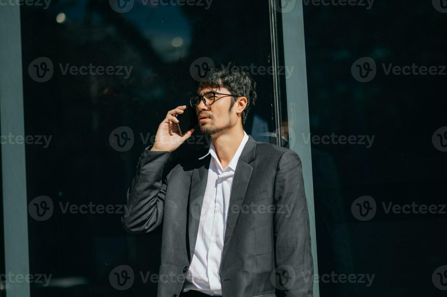 Handsome  asian female businessman use smartphone and holding laptop computer, Walk enjoy smiling while doing commuting at business center. photo