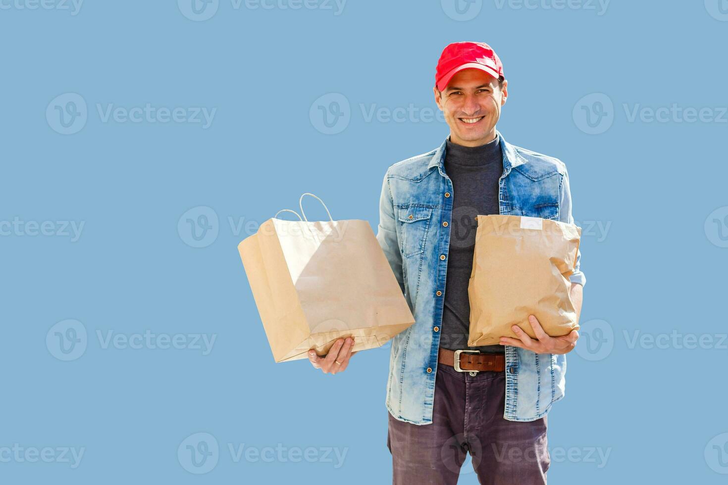 Delivery man in mask and gloves bring fresh food to customer's home. Stay home. Online shopping concept. blue background photo