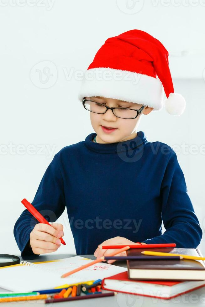 un pequeño chico escritura un letra a Papa Noel foto