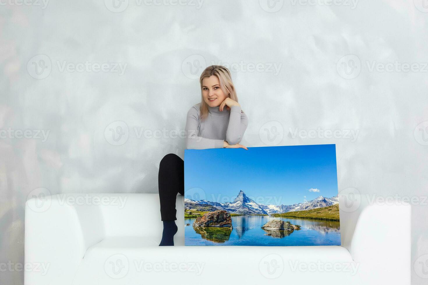 niña colgando un marco lona en un gris pared foto