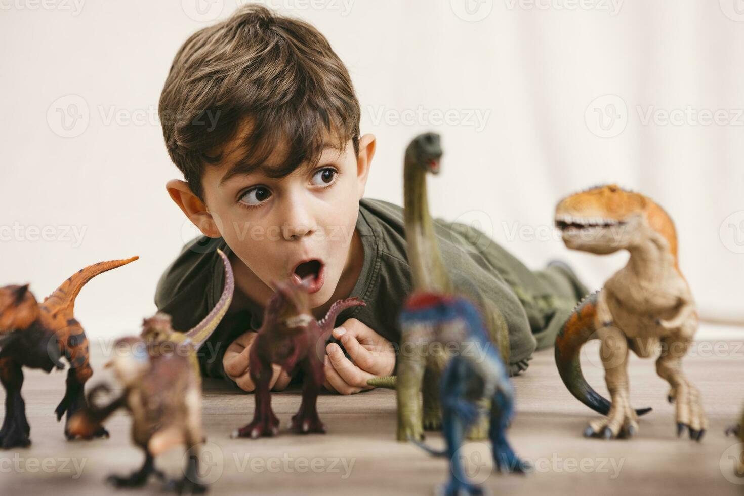 Portrait of little boy playing with toy dinosaurs photo