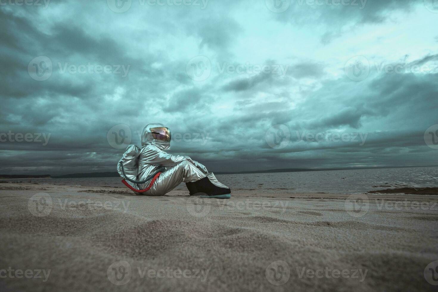 Lonely spaceman looking at lake on nameless planet photo