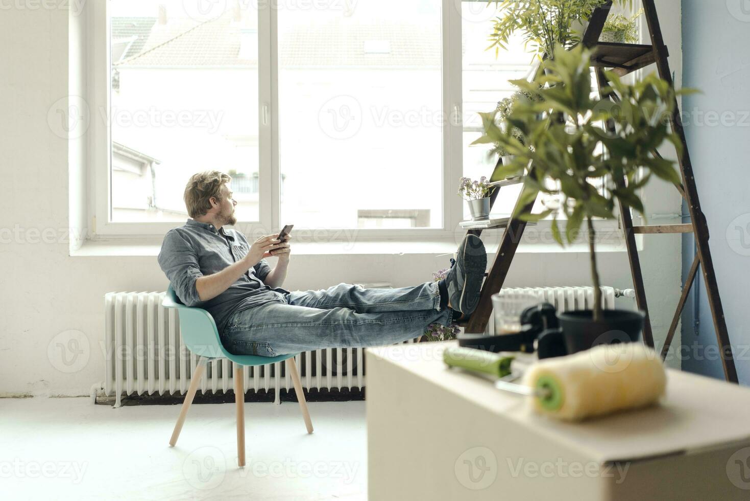 Man renovating room sitting on armchair having a break photo