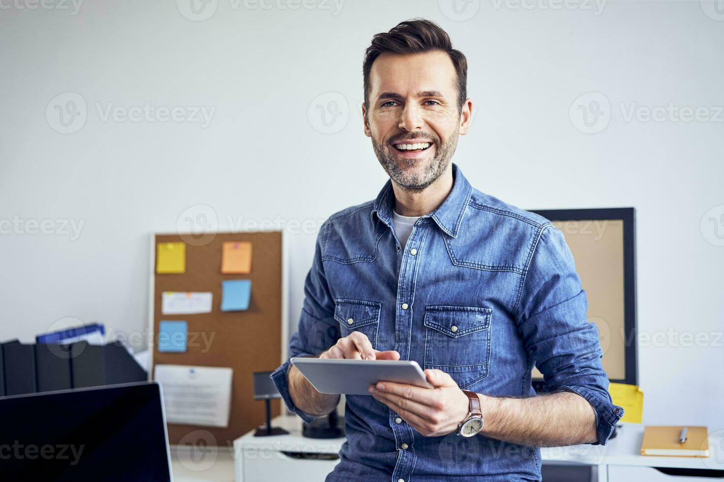 Portrait of smiling man using tablet in office photo