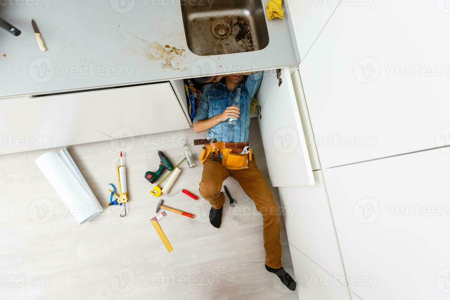 Handsome professional plumber doing sink reparation. Contractor. photo