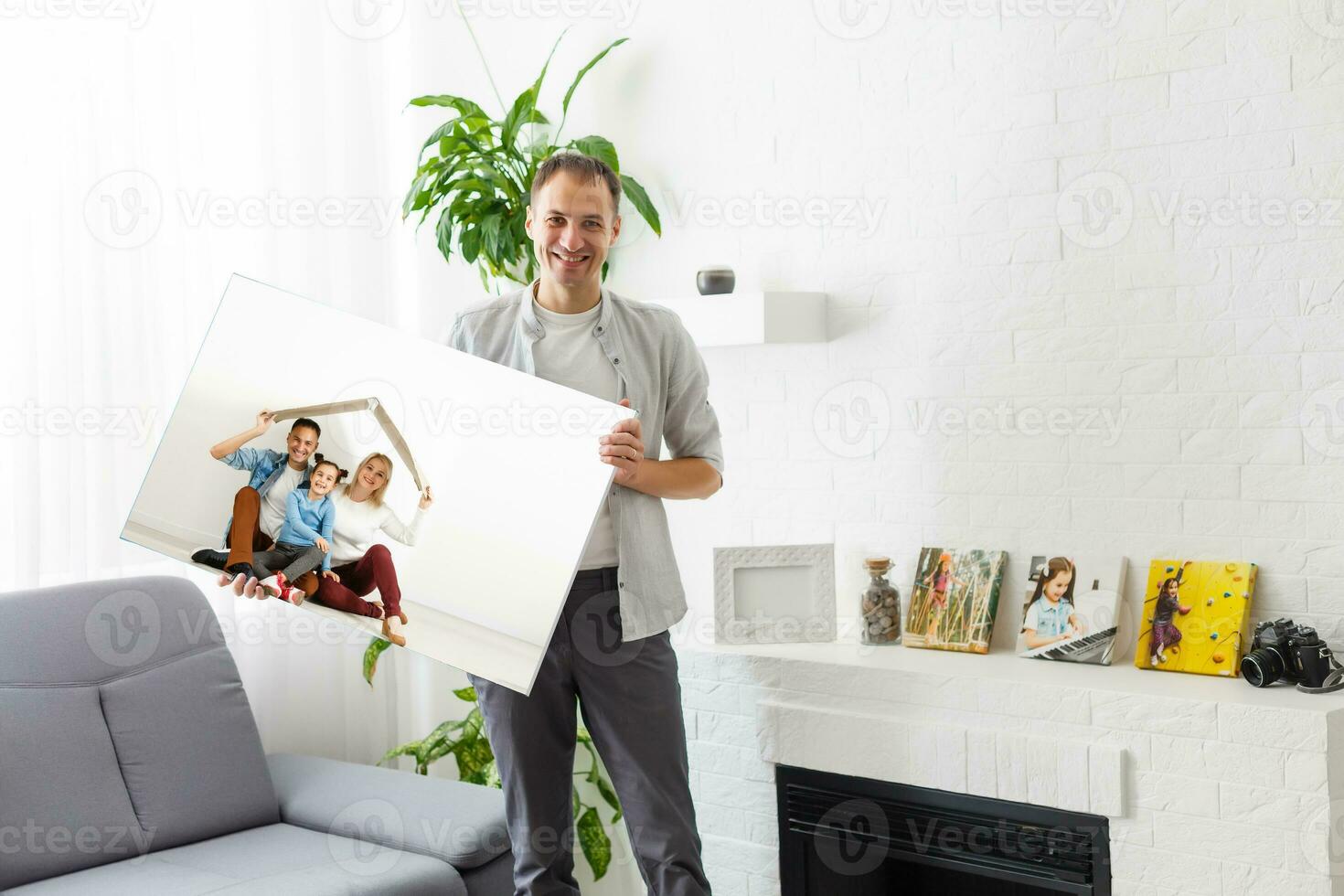 man holds photo canvas at home