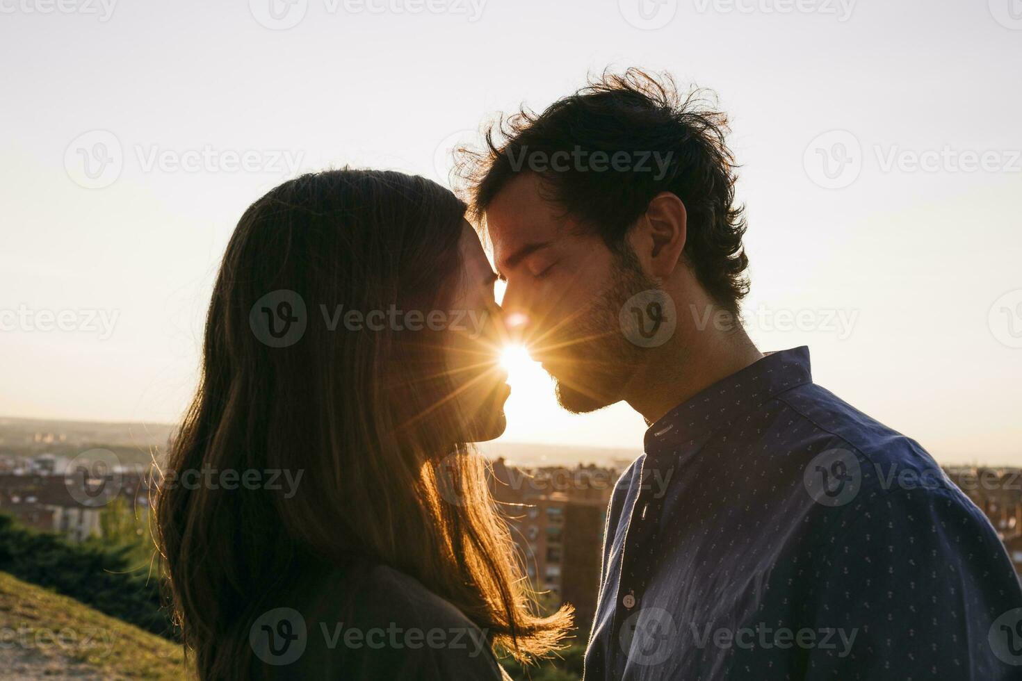 Man and woman kissing while standing against clear sky photo