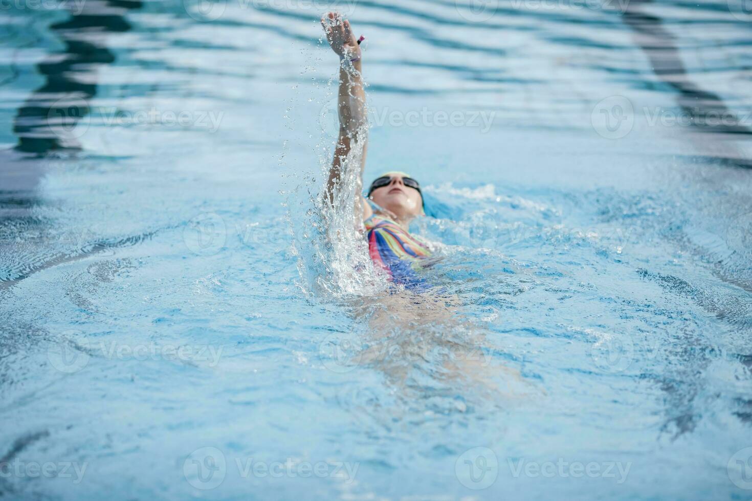 Young woman swimming in swimming pool, backstroke photo