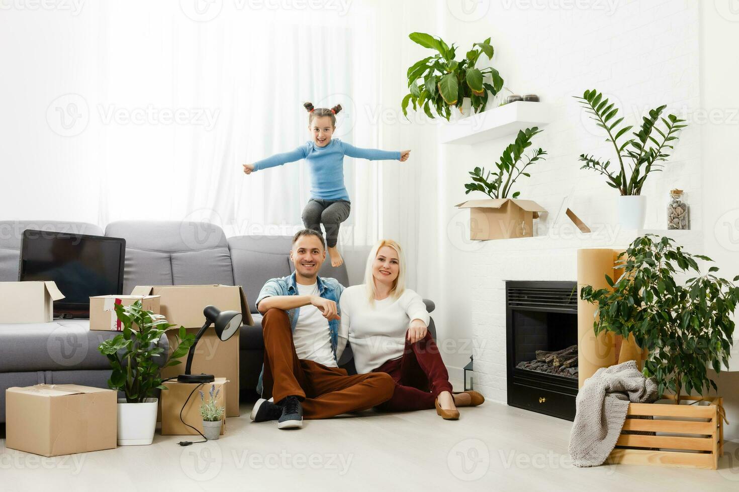 Happy family with cardboard boxes in new house at moving day. photo